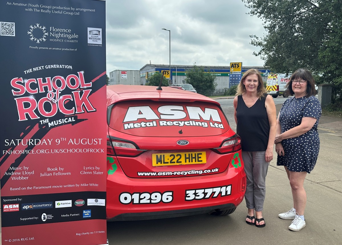 ASM staff and branded car beside a School Of Rock poster