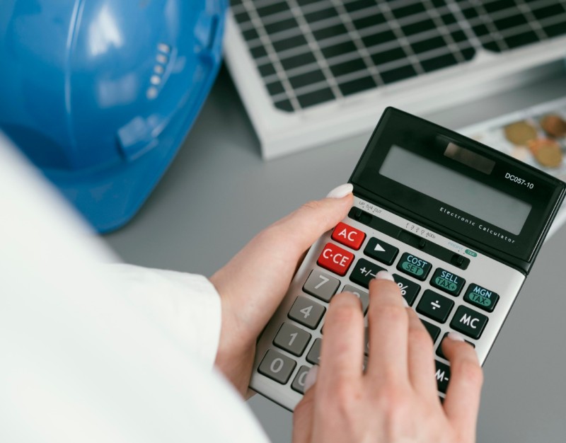 Construction worker holding a calculator