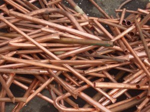 Single copper ingot on rows of shiny copper ingots or bars